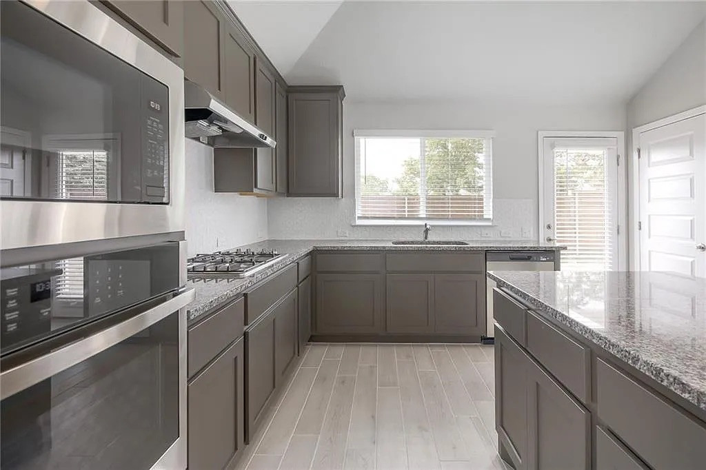 116 River Hills Drive Georgetown, TX 78628 - Photo 11 of 19 a kitchen with stainless steel appliances granite countertop a sink and a stove