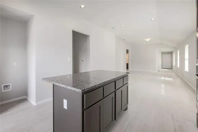 a kitchen with stainless steel appliances granite countertop a sink and a refrigerator