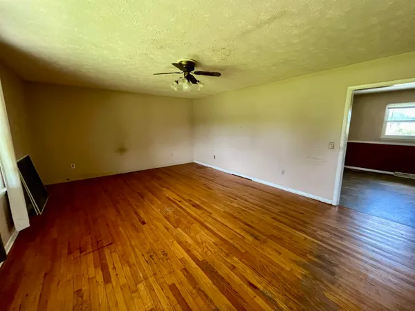 a view of a room with wooden floor and a ceiling fan