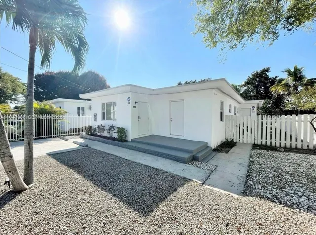 a view of a house with a backyard and a tree