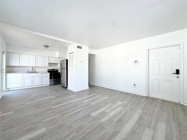 a view of a kitchen with a sink and a refrigerator