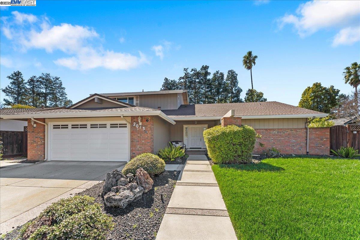 a front view of a house with a yard and potted plants