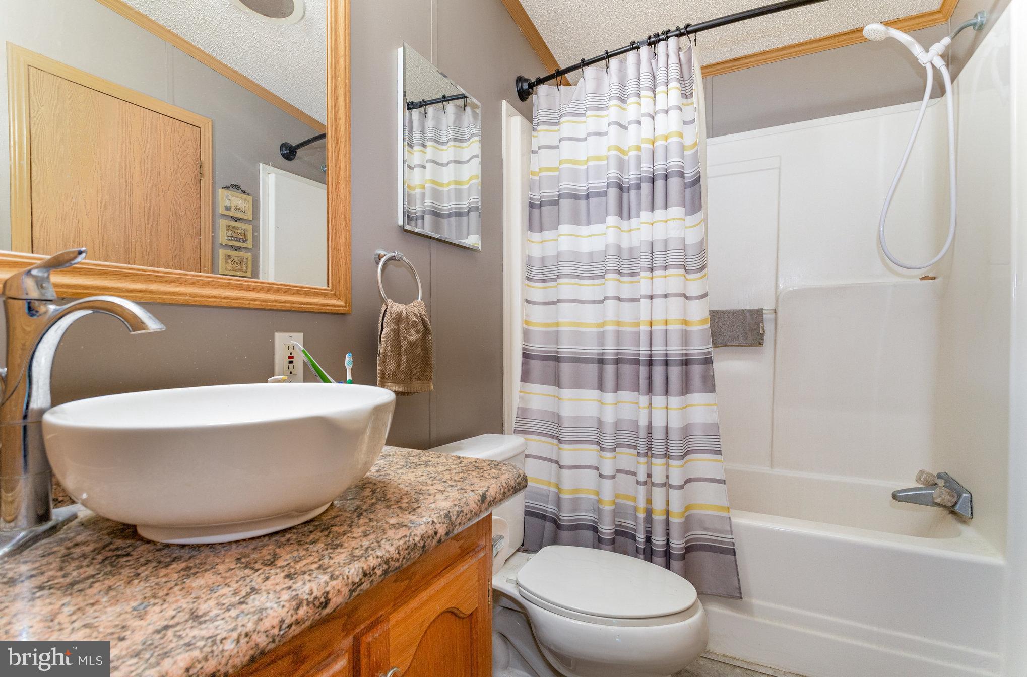1050 Lisburn Road Wellsville, PA 17365 - Photo 21 of 35 a bathroom with a granite countertop bathtub sink vanity mirror and toilet