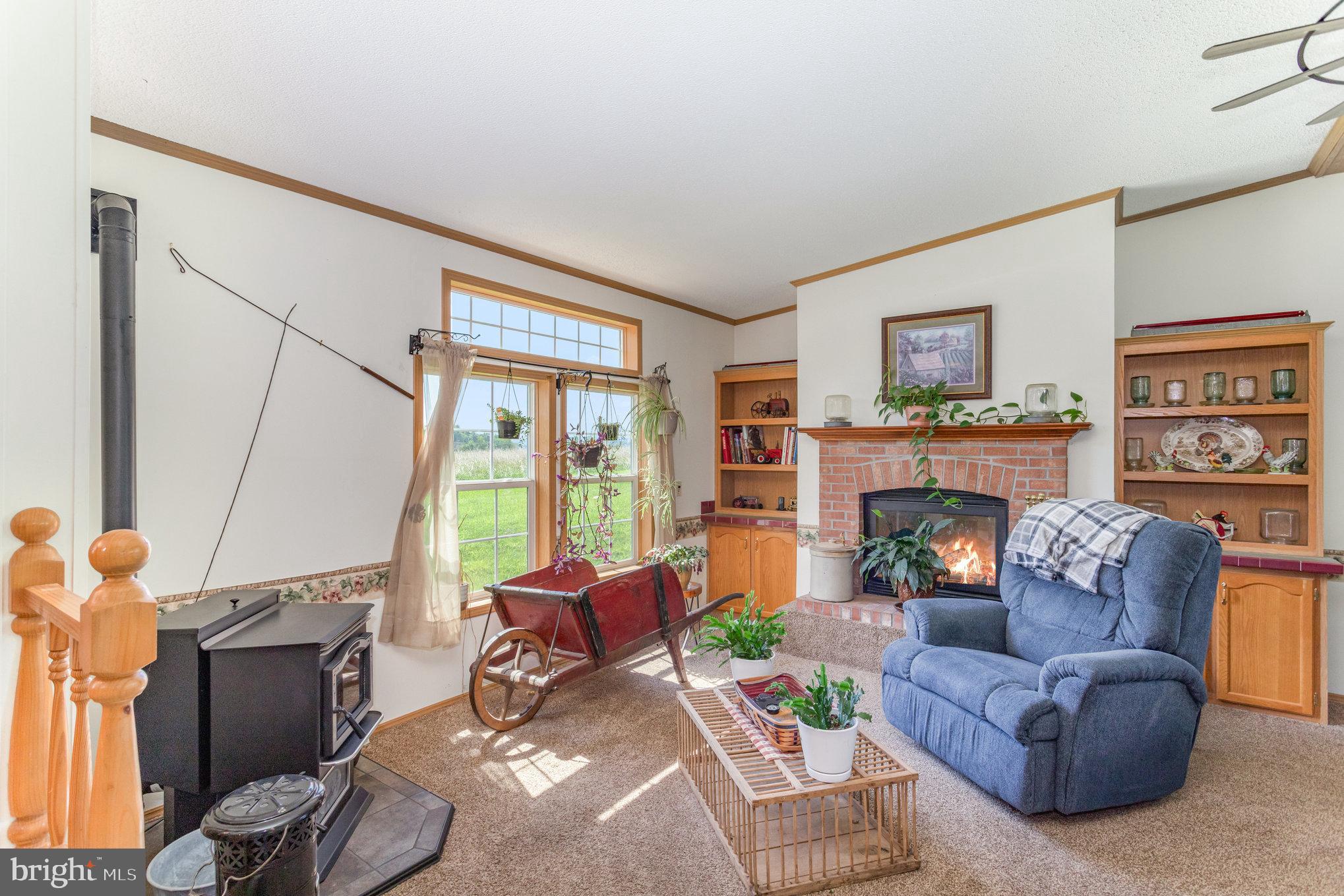1050 Lisburn Road Wellsville, PA 17365 - Photo 6 of 35 a living room with furniture a fireplace and a large window