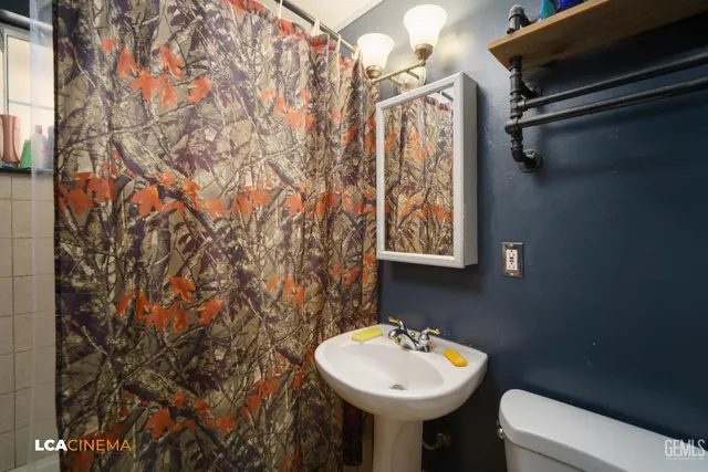 a bathroom with a sink toilet and mirror