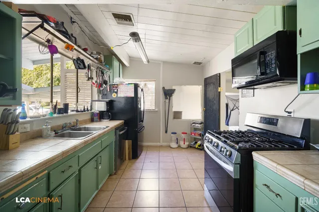 a kitchen with stainless steel appliances granite countertop a sink a stove and a refrigerator