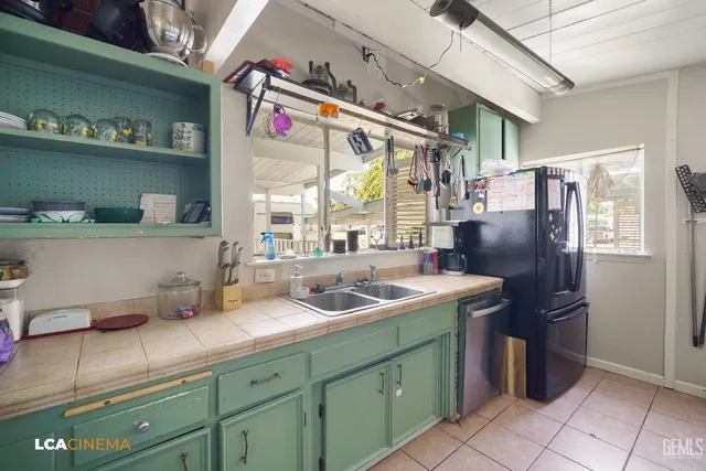 a kitchen with stainless steel appliances granite countertop a sink and a refrigerator