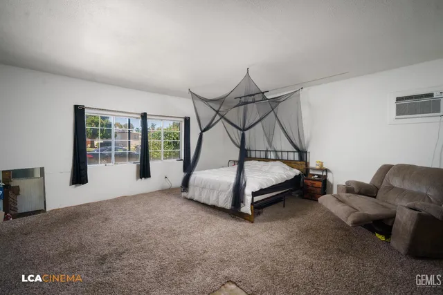 a bedroom with a bed a couch and a window