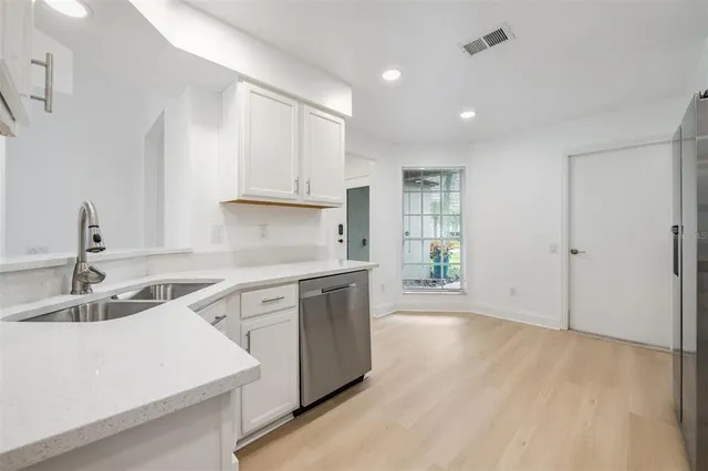a kitchen with granite countertop white cabinets and white appliances