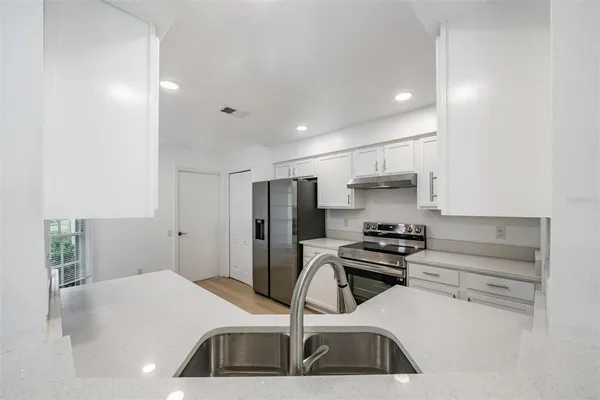 a kitchen with kitchen island a sink appliances and cabinets