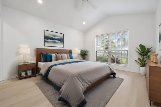 a bedroom with a large bed and a potted plant