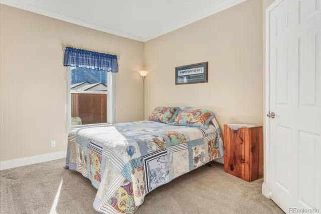a view of a bedroom with a bed and wooden floor