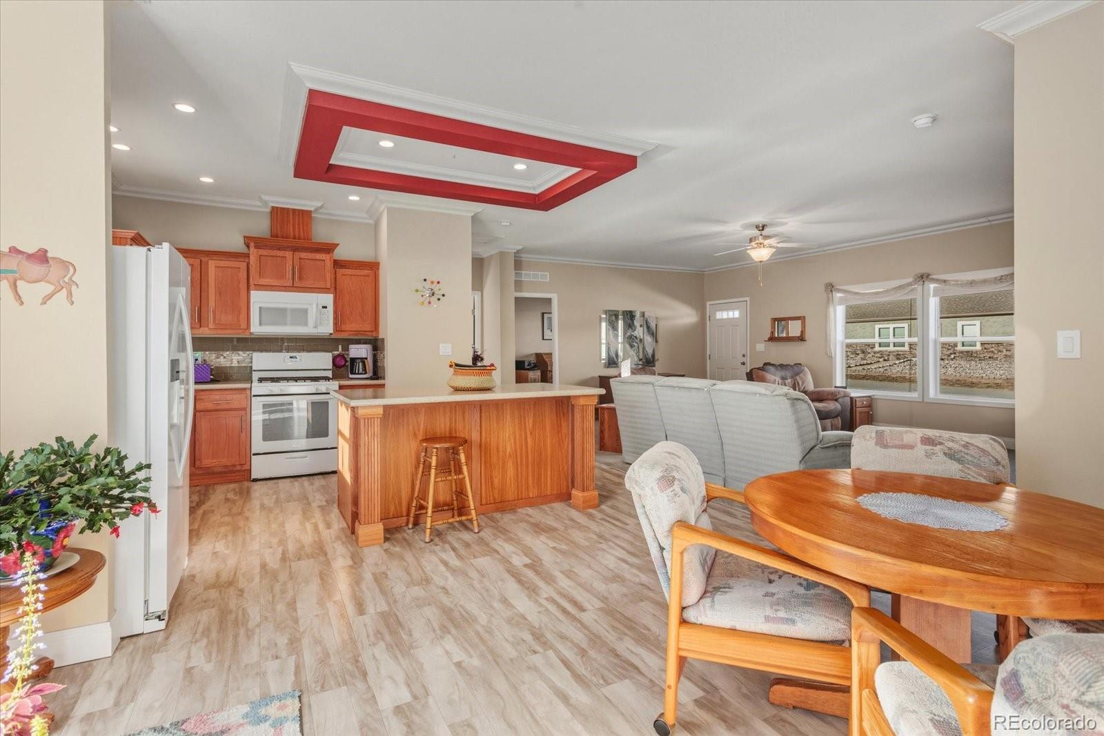 655 Quarry Station Poncha Springs, CO 81242 - Photo 6 of 42 a kitchen with stainless steel appliances kitchen island granite countertop a stove a sink dishwasher and a dining table with wooden floor