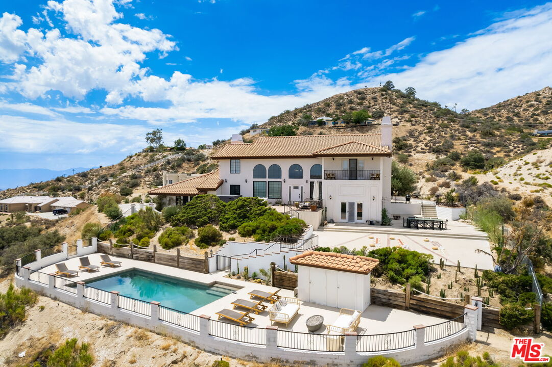 a view of a white house with a swimming pool and outdoor space