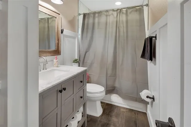 a bathroom with a sink a toilet a mirror and shower