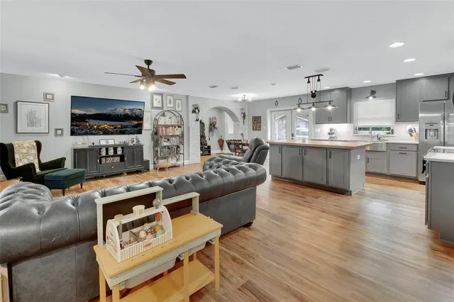 a living room with stainless steel appliances furniture and a kitchen view