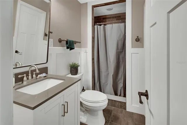 a bathroom with a sink vanity mirror and toilet