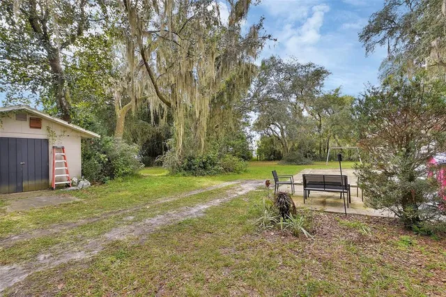 a backyard of a house with table and chairs