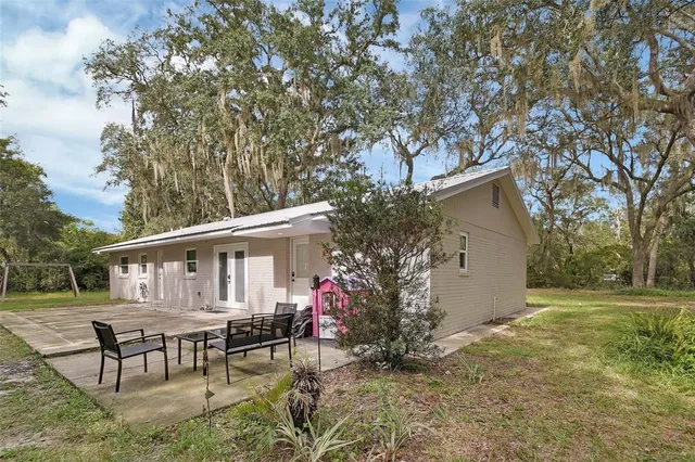 a view of a house with backyard and sitting area