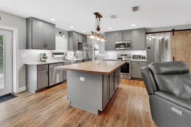 a kitchen with stainless steel appliances granite countertop a sink a stove and a refrigerator