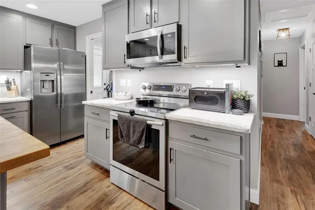 a kitchen with stainless steel appliances a stove microwave and a refrigerator