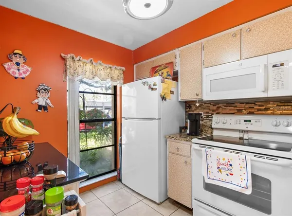 a kitchen with stainless steel appliances kitchen island granite countertop a refrigerator and a stove top oven