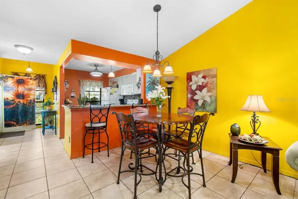 a living room with patio furniture and a chandelier