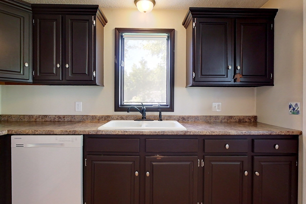 103 Main Street, Unit 10 Pepperell, MA 01463 - Photo 3 of 22 a kitchen with granite countertop cabinets sink and window