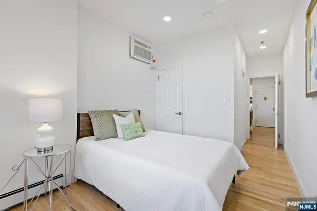 a spacious bedroom with a bed and a lamp