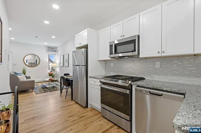 a kitchen with stainless steel appliances granite countertop a stove microwave and cabinets