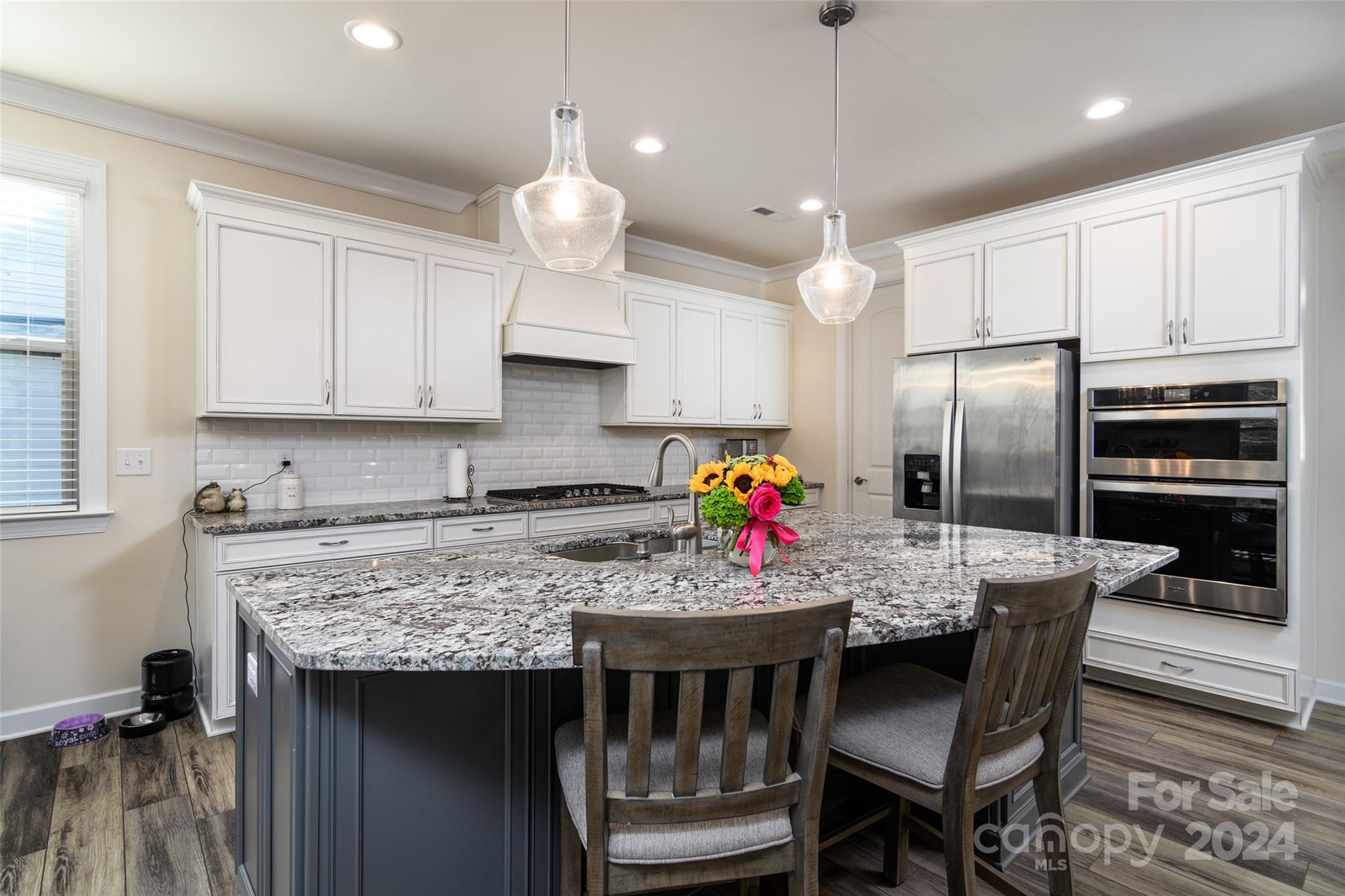 1435 Liberty Row Drive Fort Mill, SC 29708 - Photo 8 of 34 a kitchen with stainless steel appliances granite countertop a stove refrigerator a sink dishwasher a dining table and chairs with wooden floor