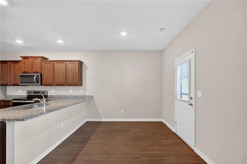 1003 Nandina Court Villa Rica, GA 30180 - Photo 11 of 43 a view of a kitchen with a sink wooden cabinets and refrigerator