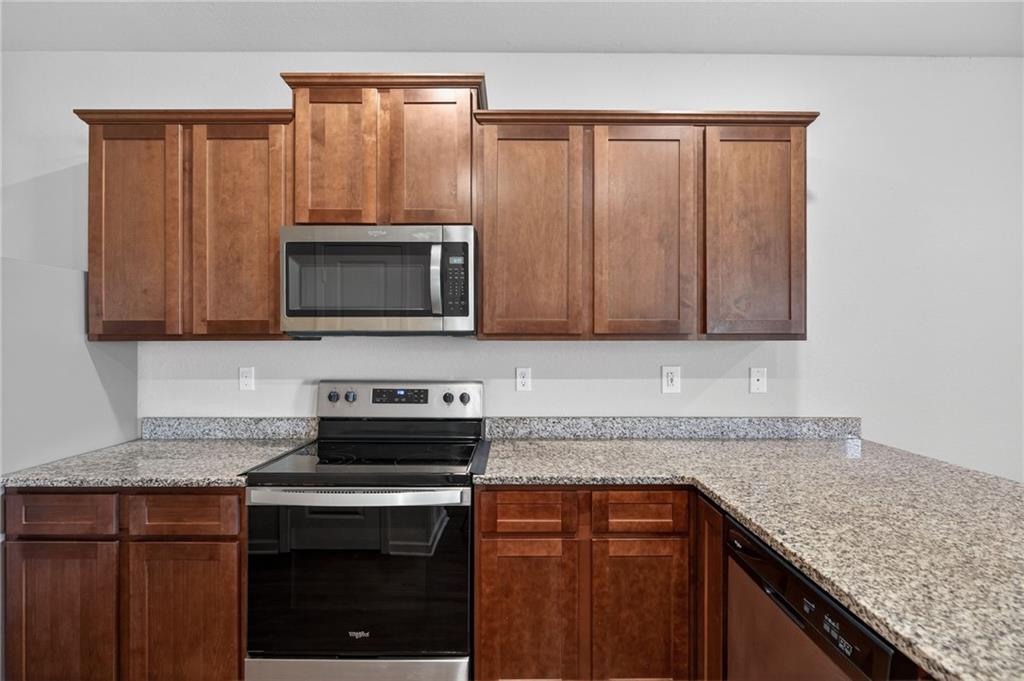 1003 Nandina Court Villa Rica, GA 30180 - Photo 7 of 43 a kitchen with granite countertop a sink stove and microwave