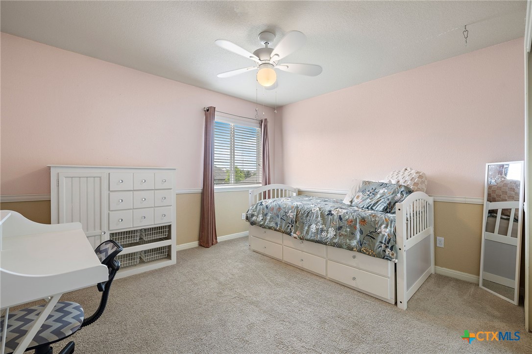 326 Comal Run Hutto, TX 78634 - Photo 13 of 23 a bedroom with a bed and a ceiling fan