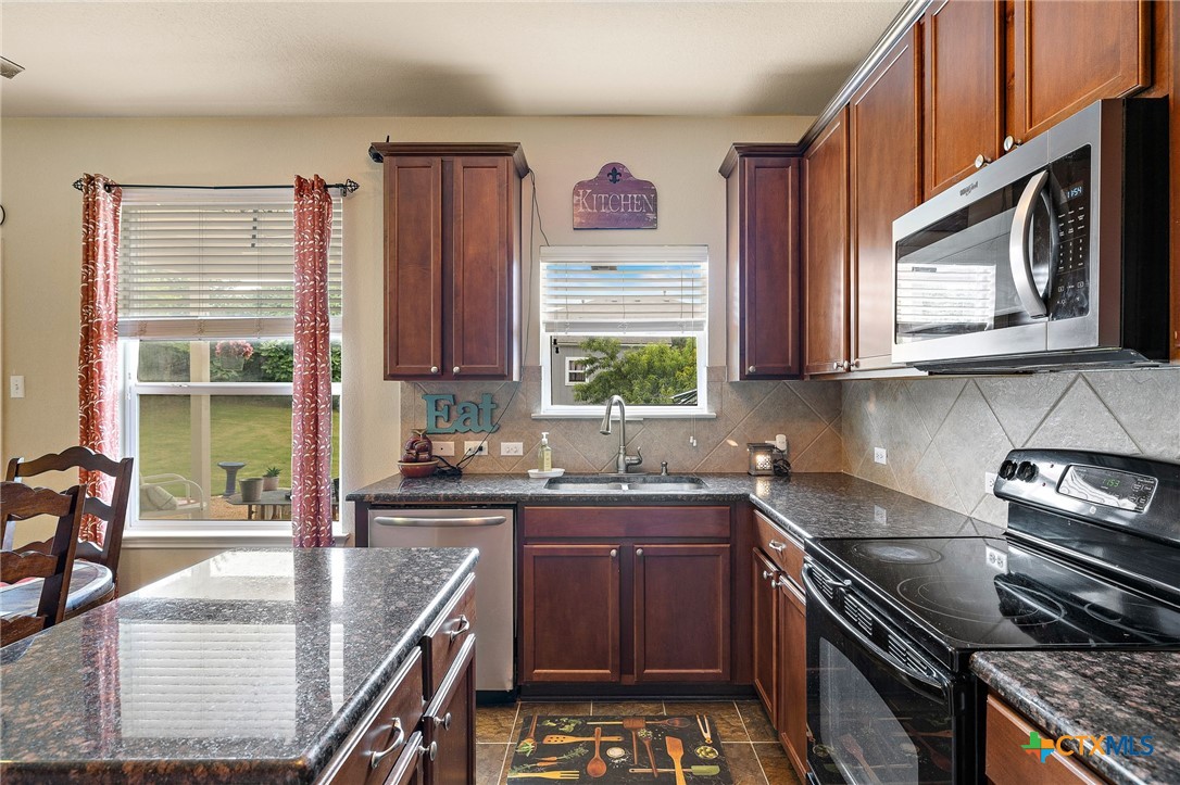 326 Comal Run Hutto, TX 78634 - Photo 4 of 23 a kitchen with stainless steel appliances granite countertop a stove a sink and a microwave