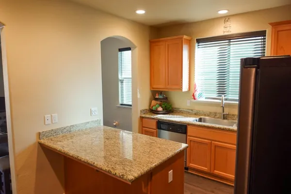 a kitchen with stainless steel appliances granite countertop a sink and a refrigerator