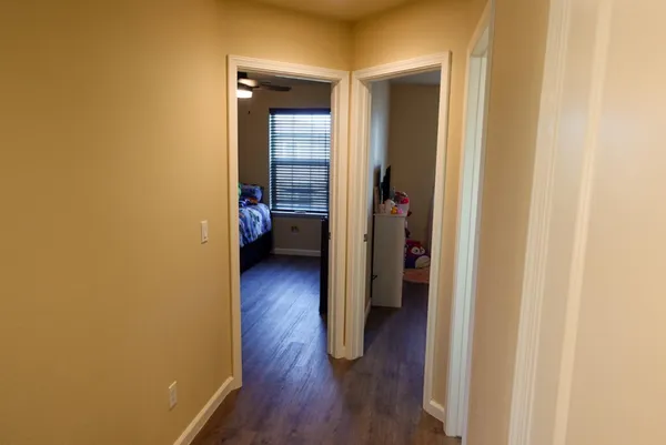 a view of a hallway with wooden floor and closet