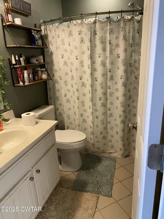 a bathroom with a toilet and a shower curtain