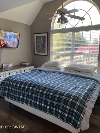 a bedroom with a bed next to a window