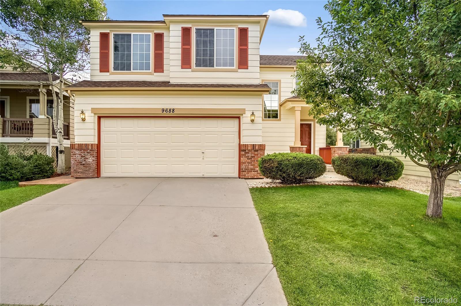 9688 Queenscliffe Drive Highlands Ranch, CO 80130 - Photo 2 of 34 a front view of house and yard with trees