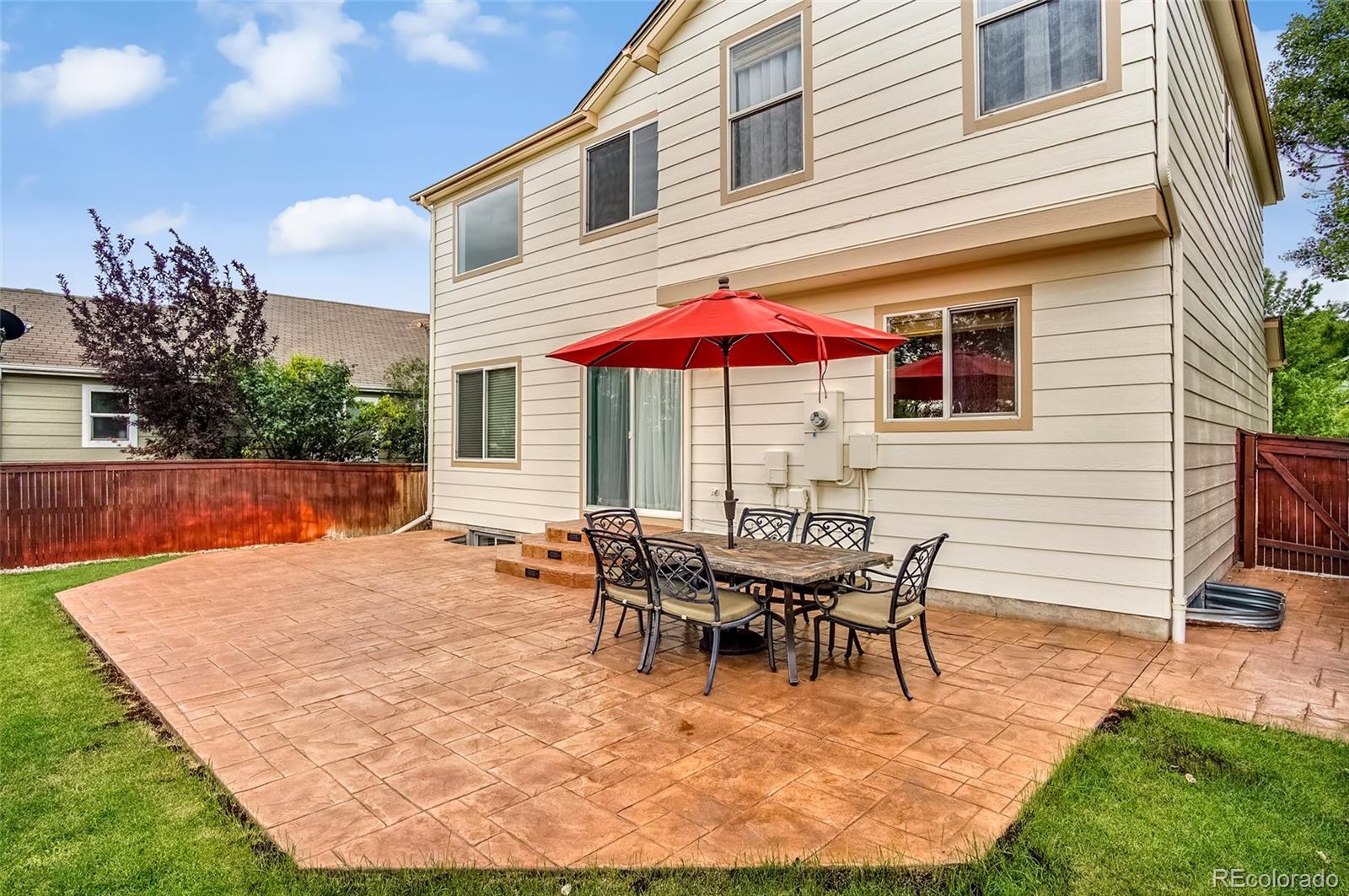 9688 Queenscliffe Drive Highlands Ranch, CO 80130 - Photo 33 of 34 a patio with a table and chairs under an umbrella