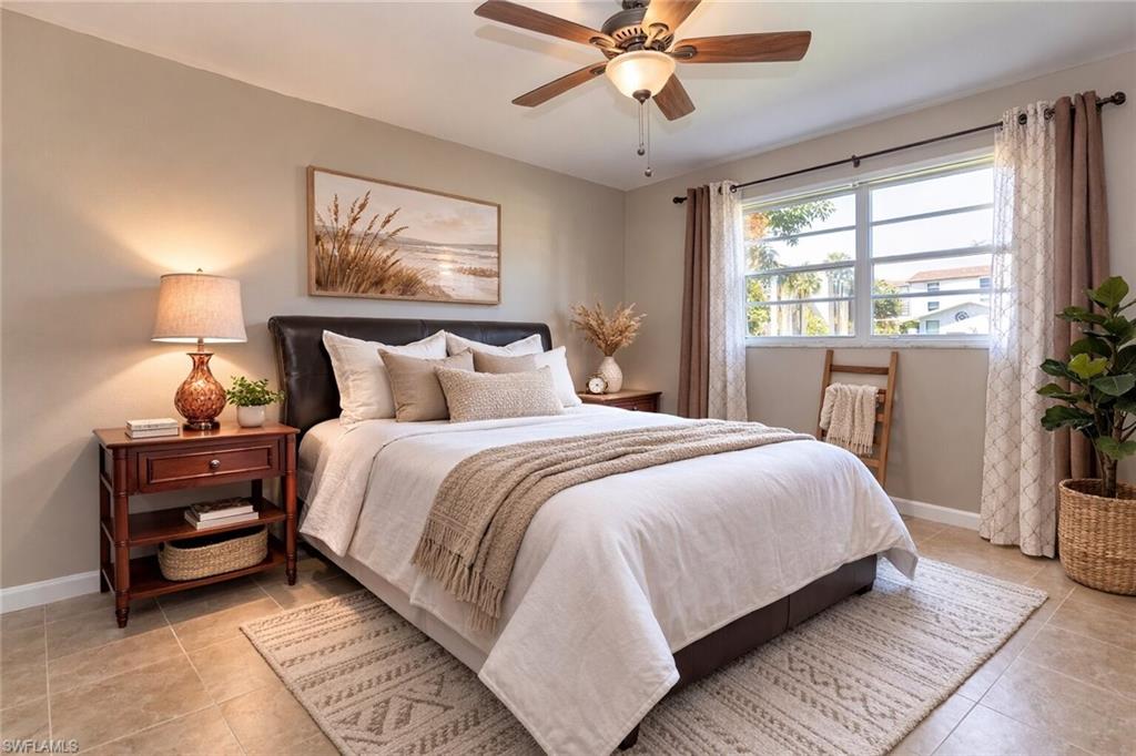 4290 Gulfstream Drive, Unit 5 Naples, FL 34112 - Photo 7 of 16 a bedroom with a large bed and a chandelier