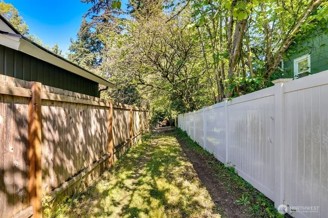 a view of a yard with wooden fence