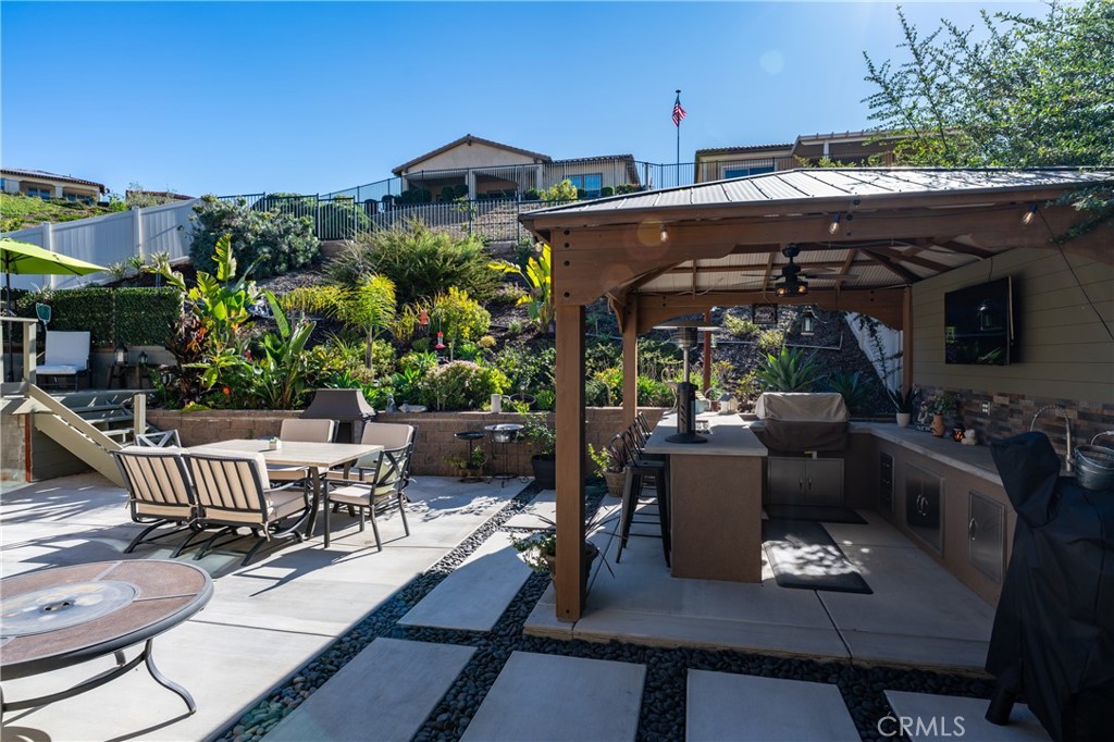 11137 Briar Rose Court Corona, CA 92883 - Photo 61 of 75 a view of a patio with table and chairs a barbeque