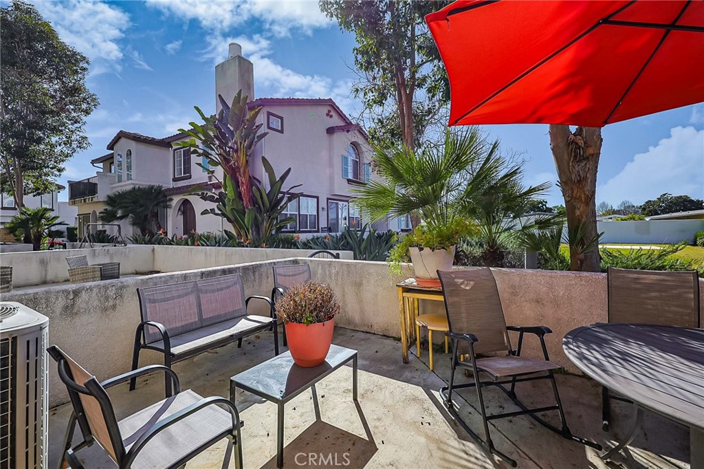 310 Sunset Way, Unit 5 Oceanside, CA 92058 - Photo 18 of 41 a view of a patio with table and chairs under an umbrella
