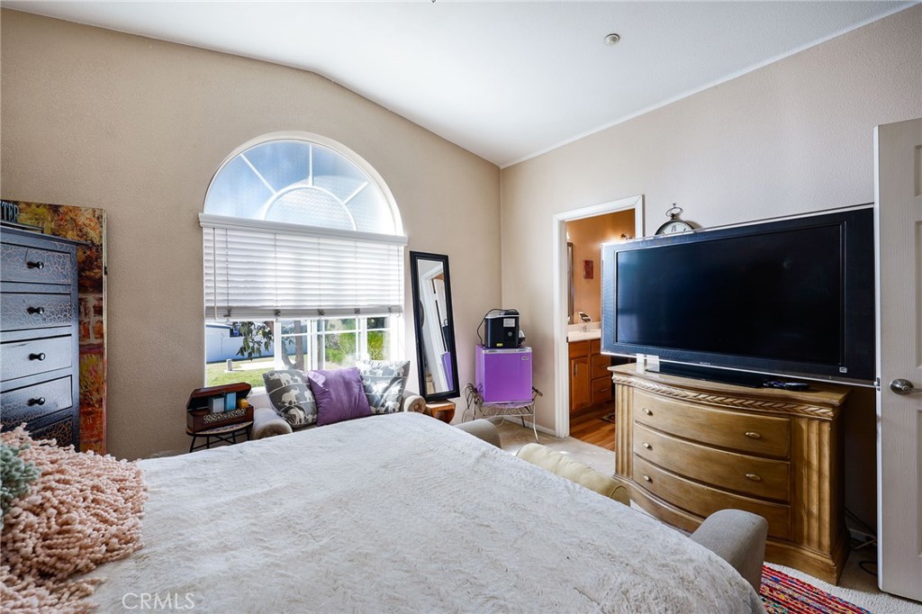 310 Sunset Way, Unit 5 Oceanside, CA 92058 - Photo 25 of 41 a bedroom with a bed and a flat tv screen on dresser