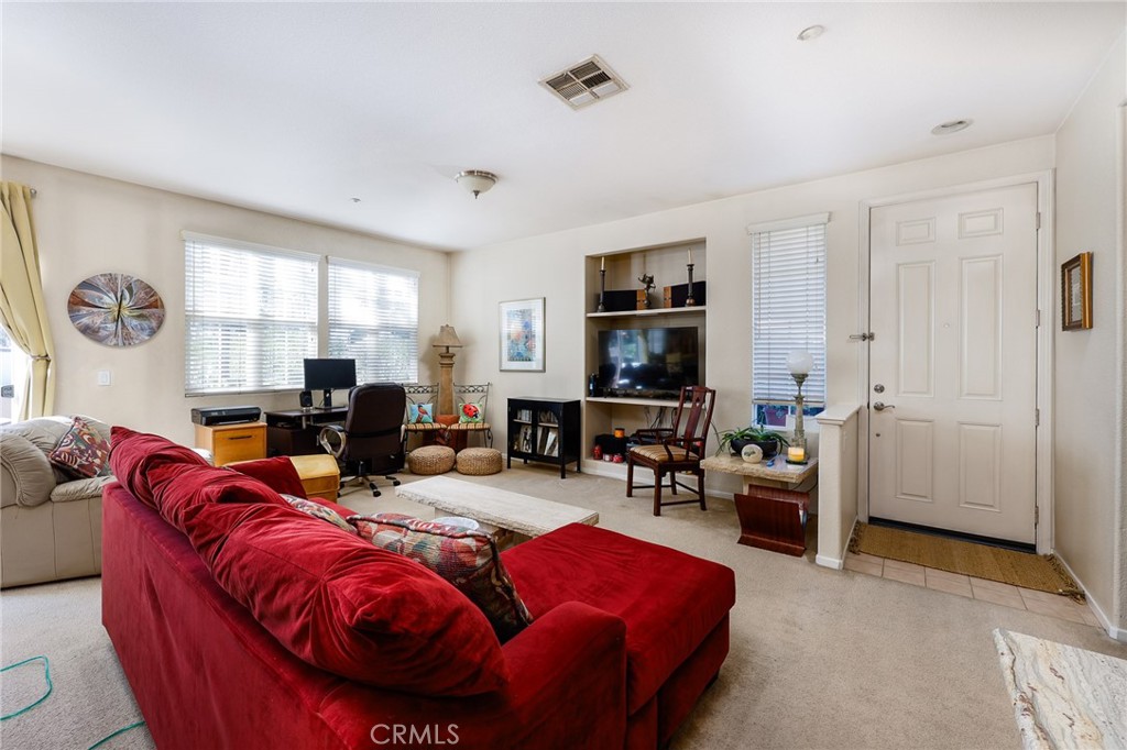 310 Sunset Way, Unit 5 Oceanside, CA 92058 - Photo 6 of 41 a living room with furniture a large window and bookshelf