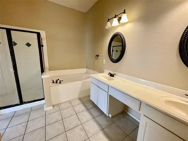 a bathroom with a sink mirror and tub