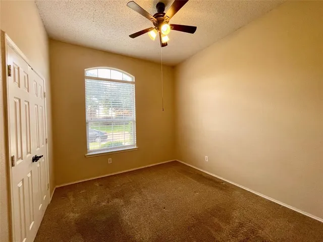a view of a room with a window and a ceiling fan