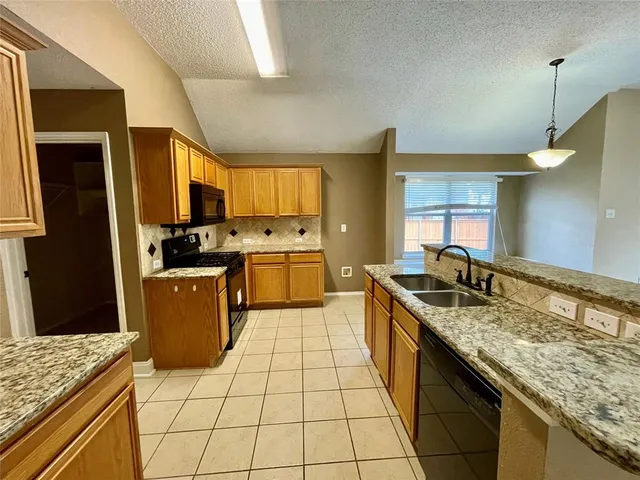 a kitchen with a stove sink and refrigerator